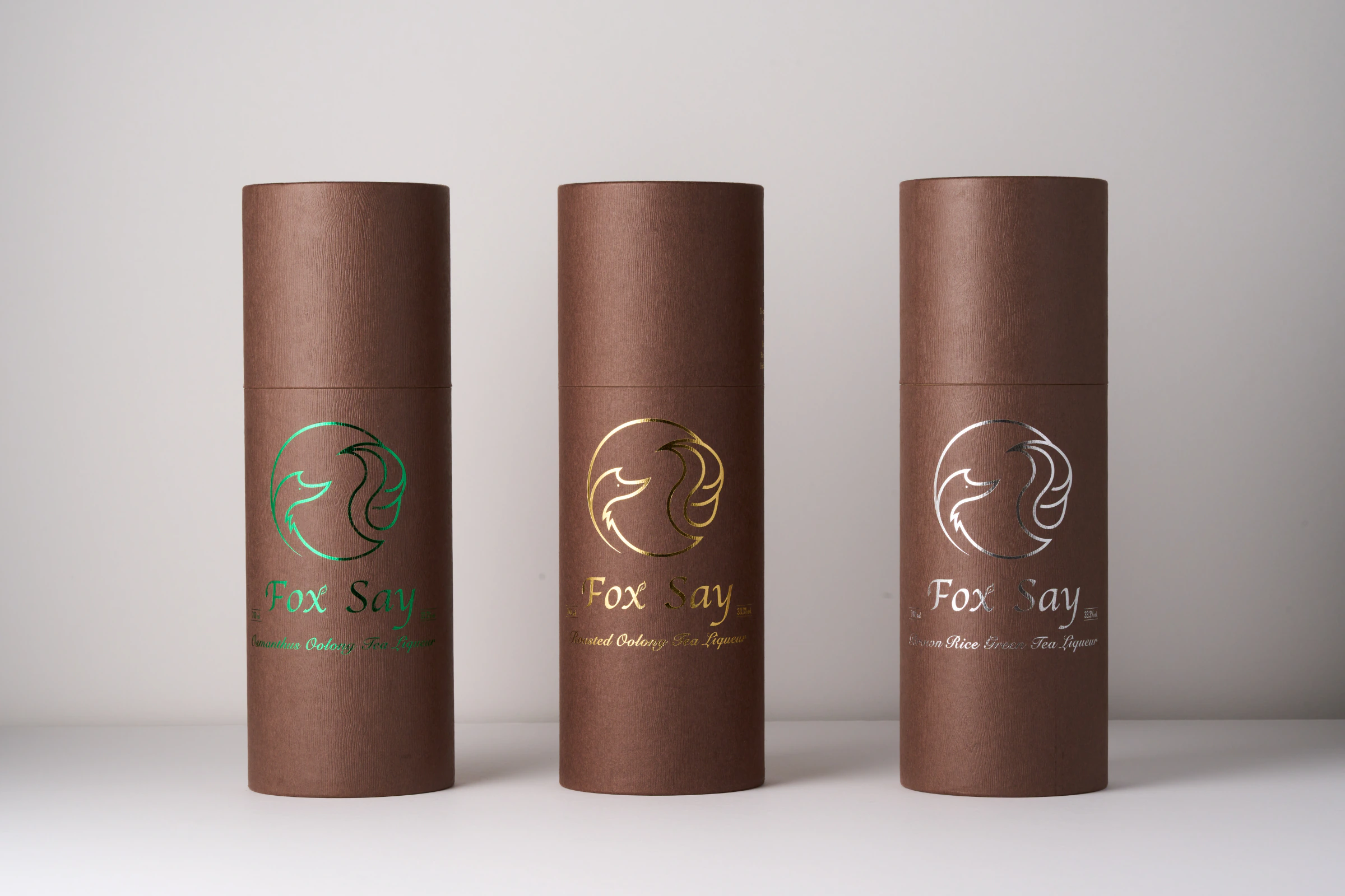 狐說茶酒三款綠金白標誌圓筒包裝的直立攝影